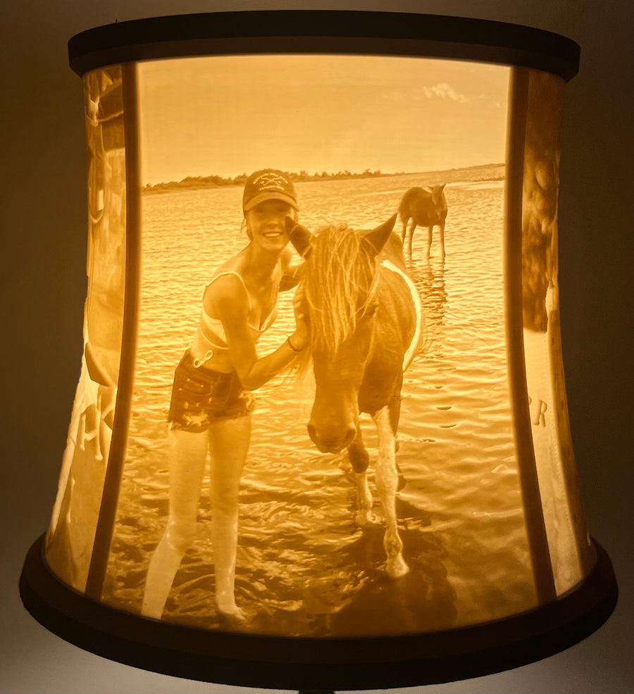 Lit lithophane lamp shade showing a photo of a woman with a horse on the beach