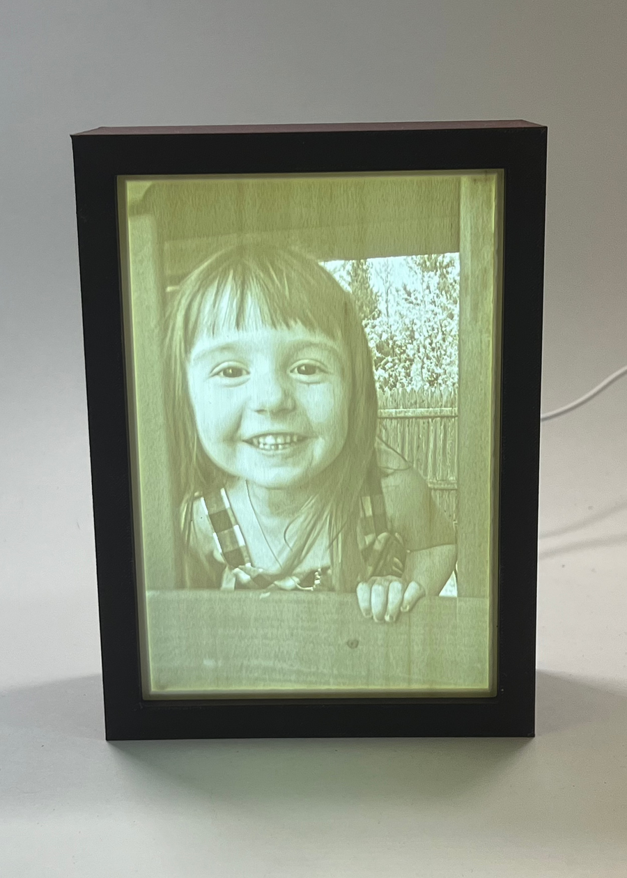 Lit 5x7 lithophane light box showing a photo of a smiling young girl
